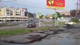 В Новосибирске мощный поток воды во время ливня смыл асфальт с дороги